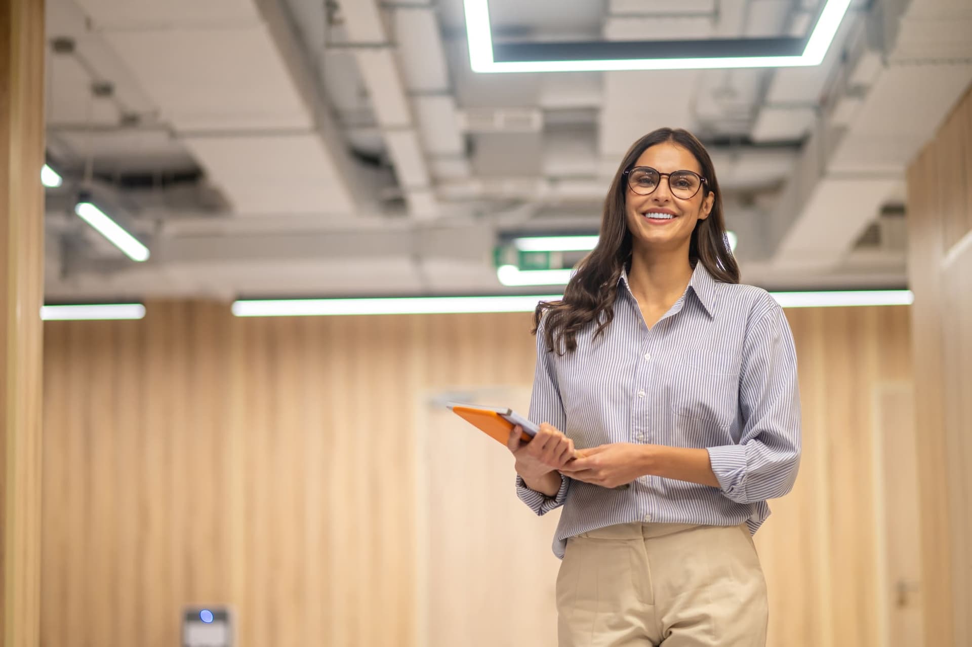 Líder sorrindo em ambiente corporativo iluminado