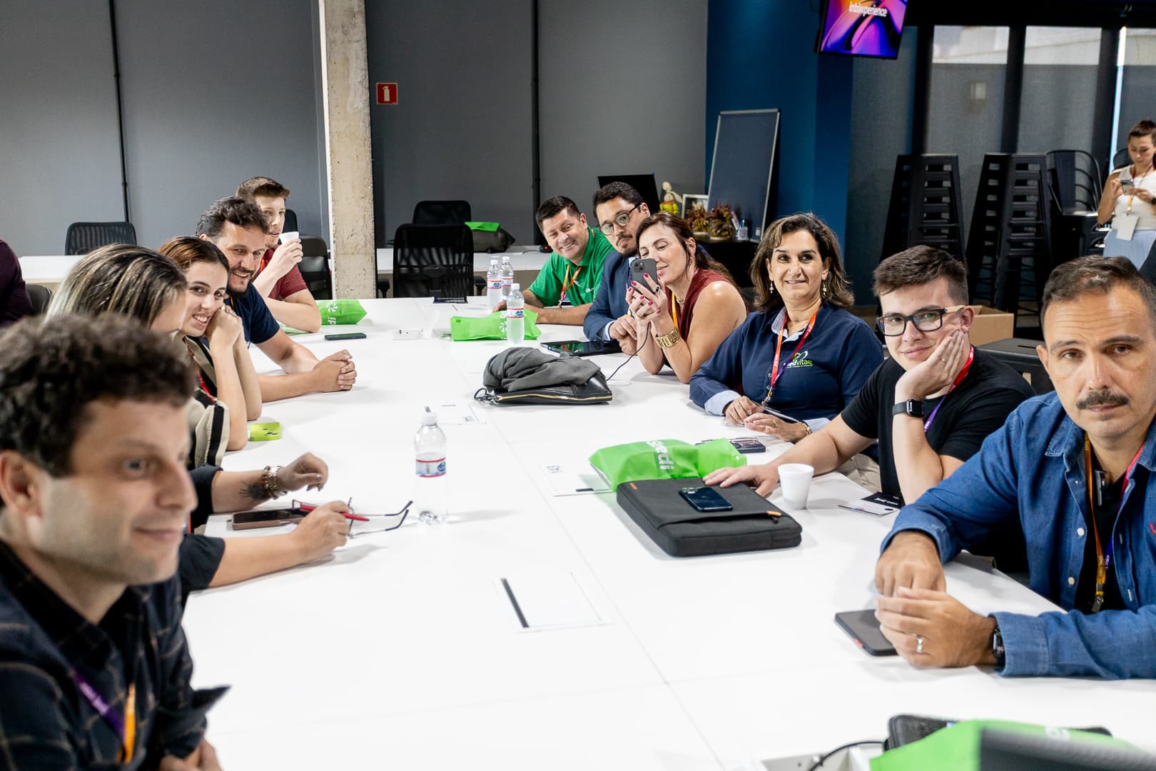 Participantes reunidos em mesa longa durante uma dinâmica de grupo