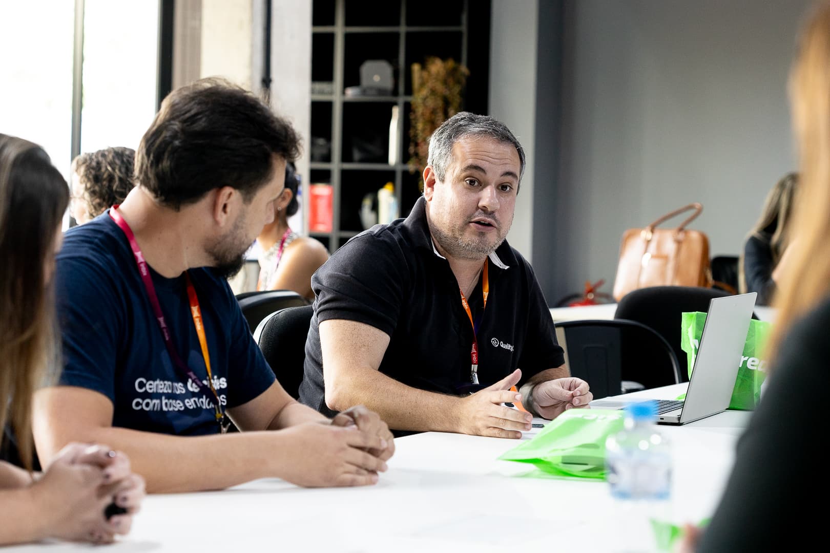 Participante expondo uma ideia em dinâmica de grupo ao redor da mesa