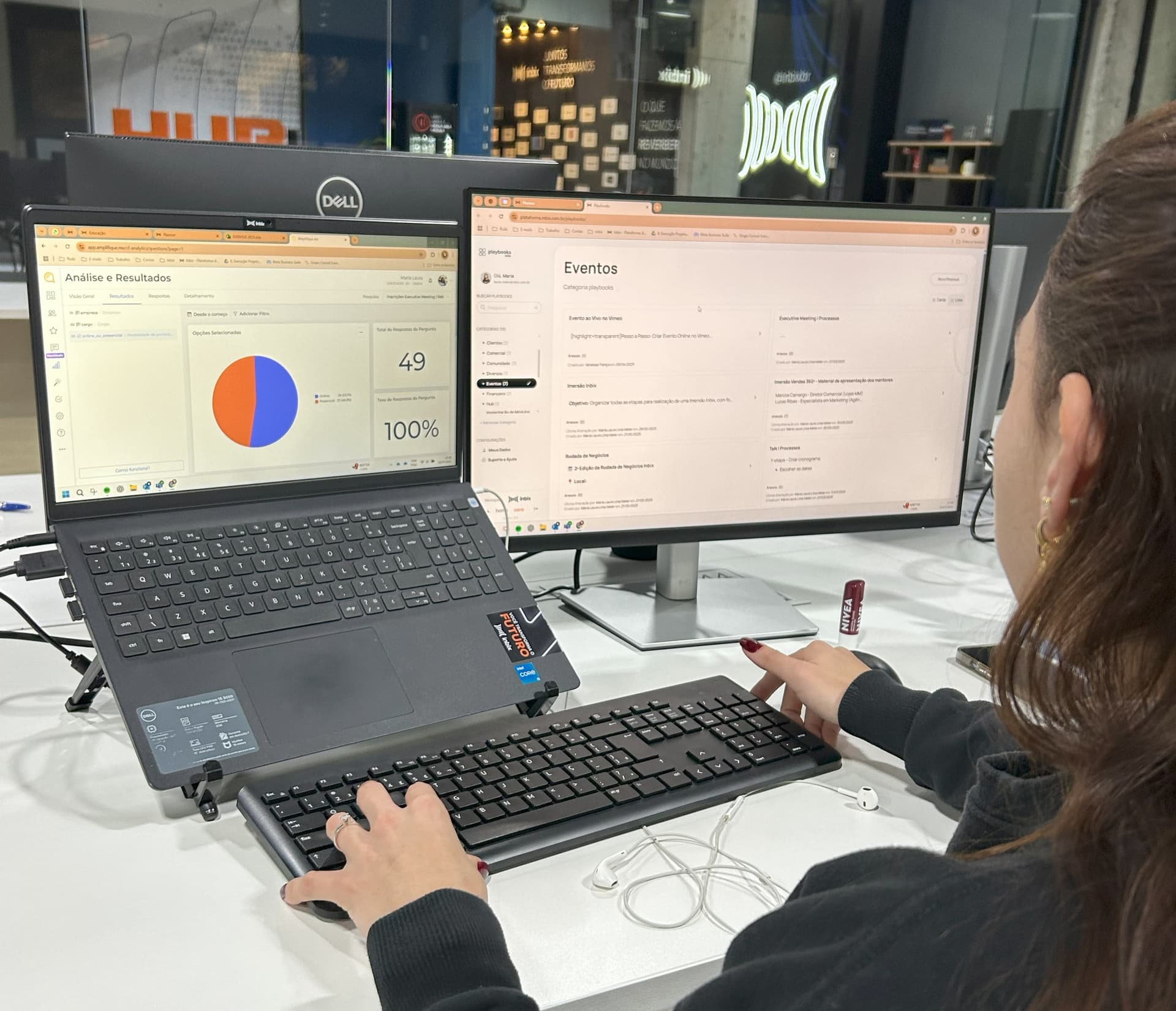 Profissional analisando o painel de resultados de treinamento em dois monitores