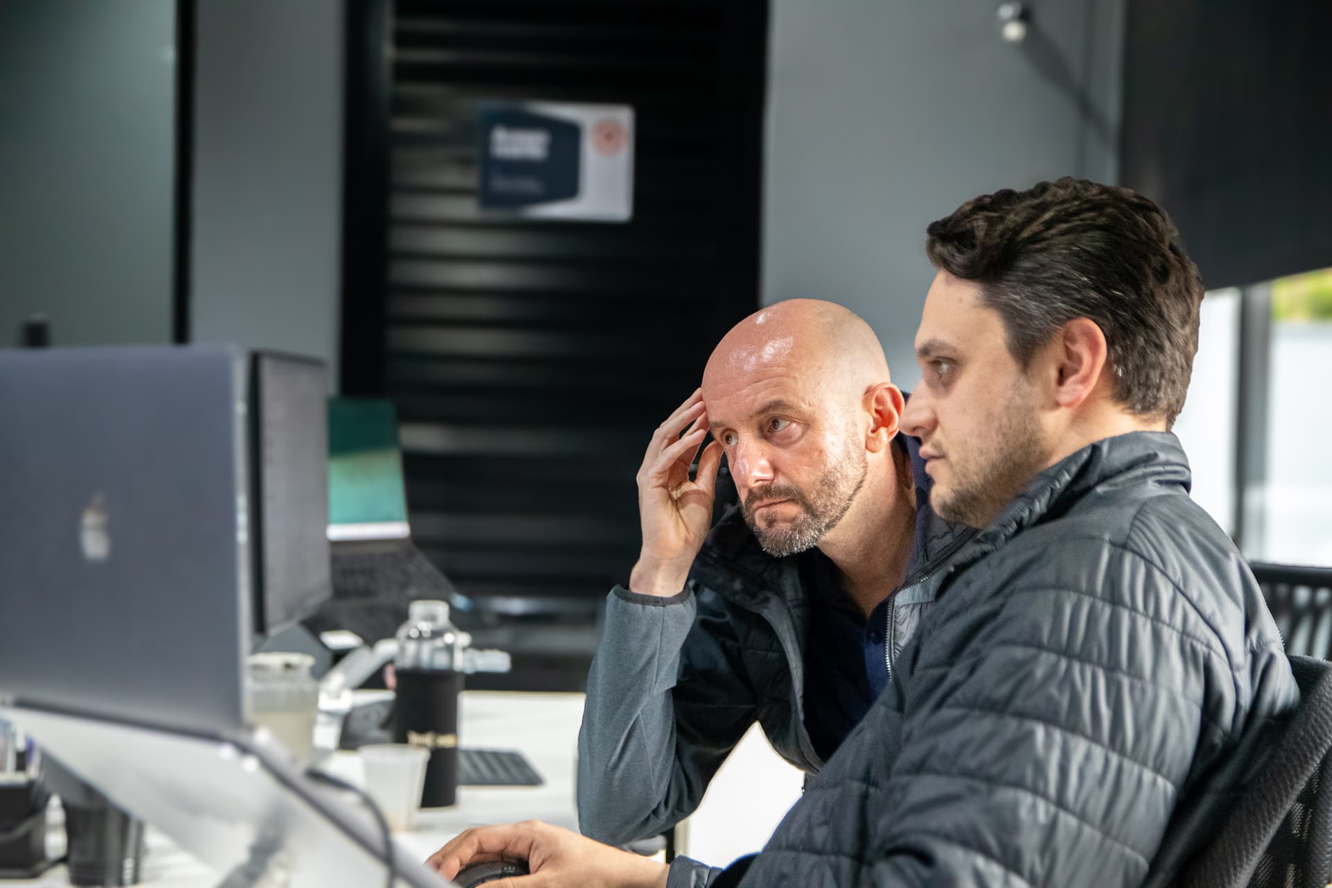 Dois profissionais analisando juntos uma tela de computador