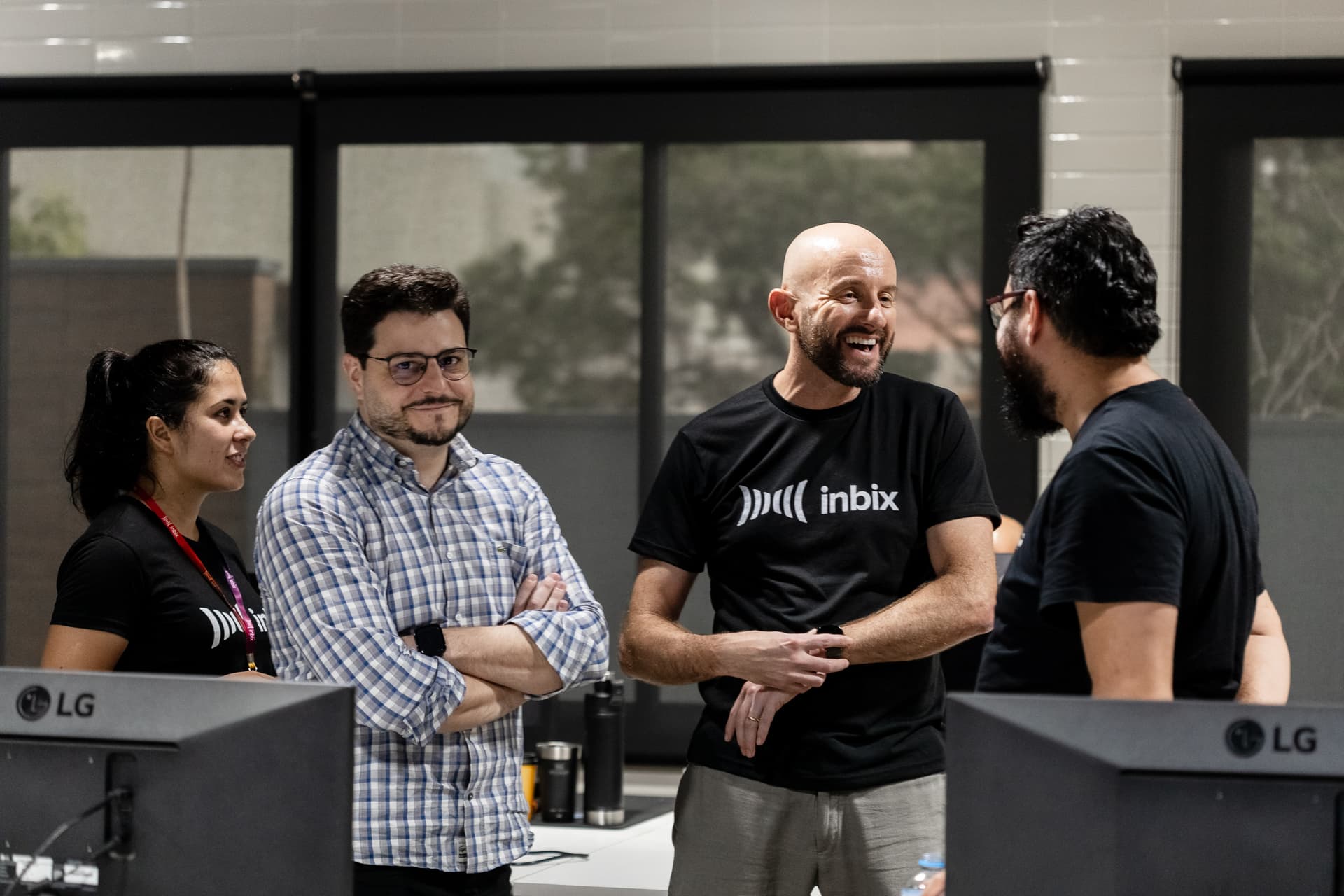 Profissionais da Inbix conversando em pé durante um evento