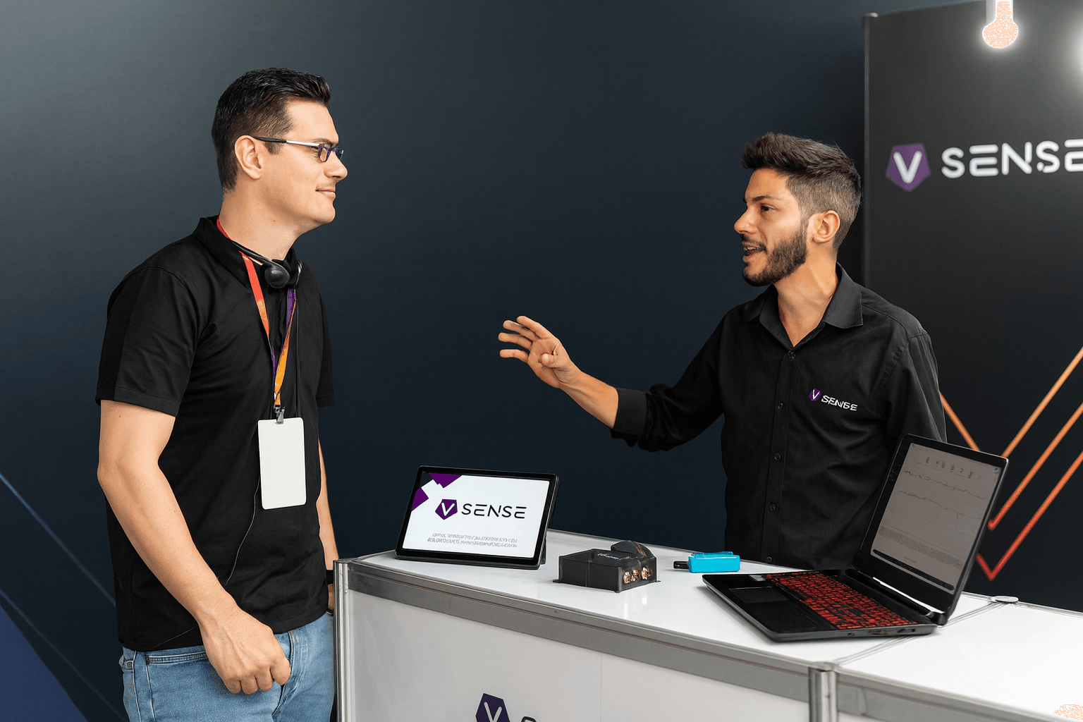 Dois profissionais conversando no estande de uma empresa de tecnologia