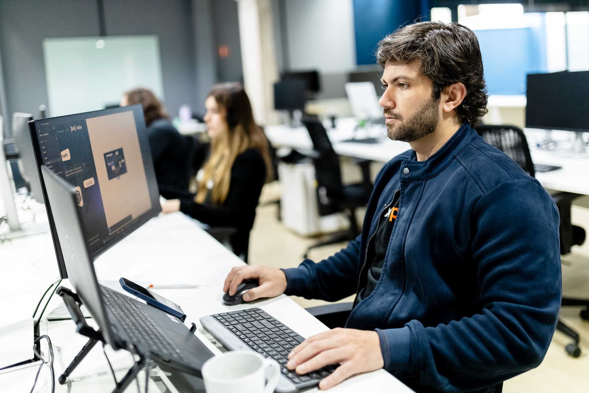 Profissional trabalhando ao computador em escritório aberto