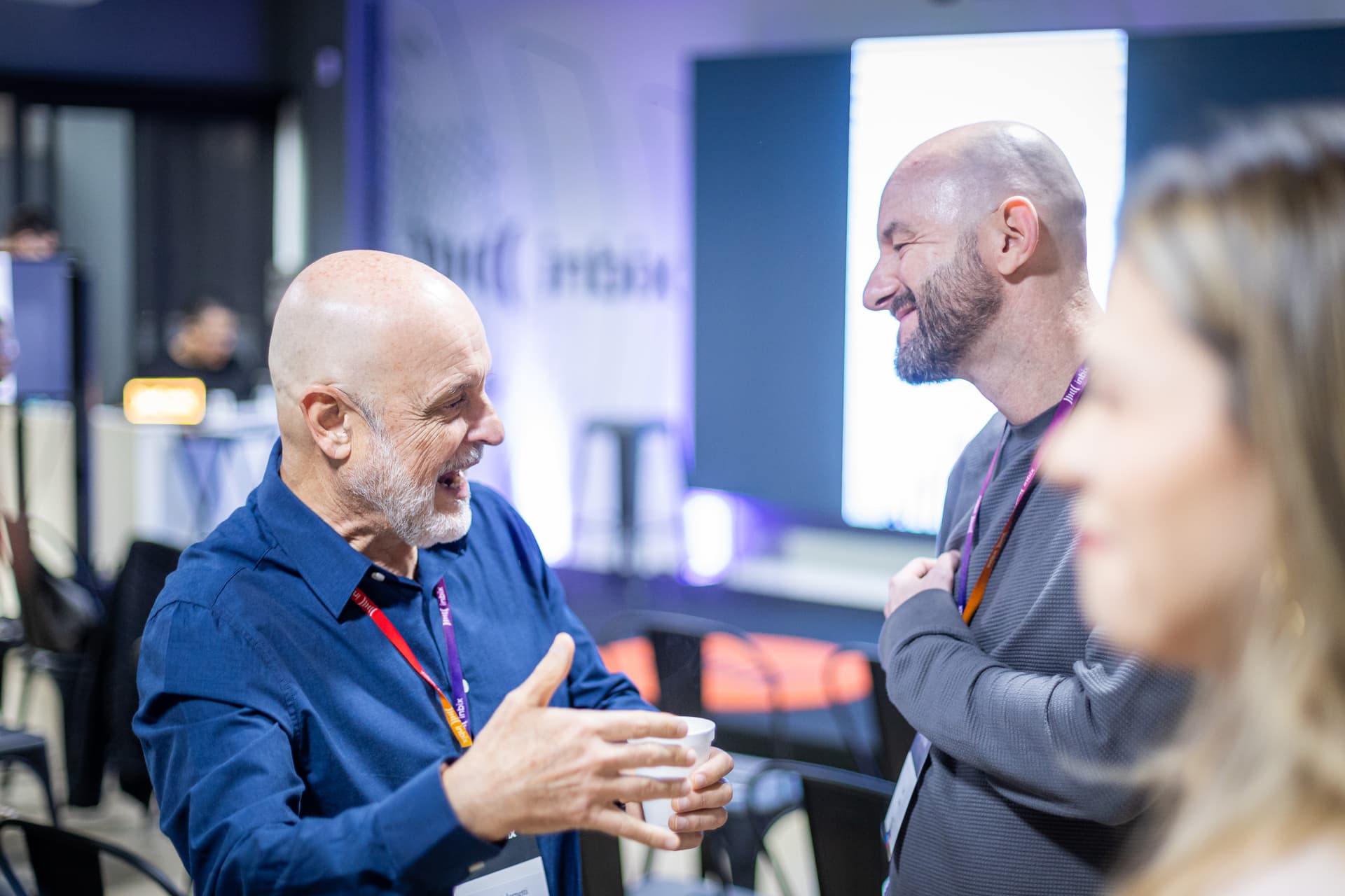 Dois profissionais conversando durante o intervalo de um evento corporativo