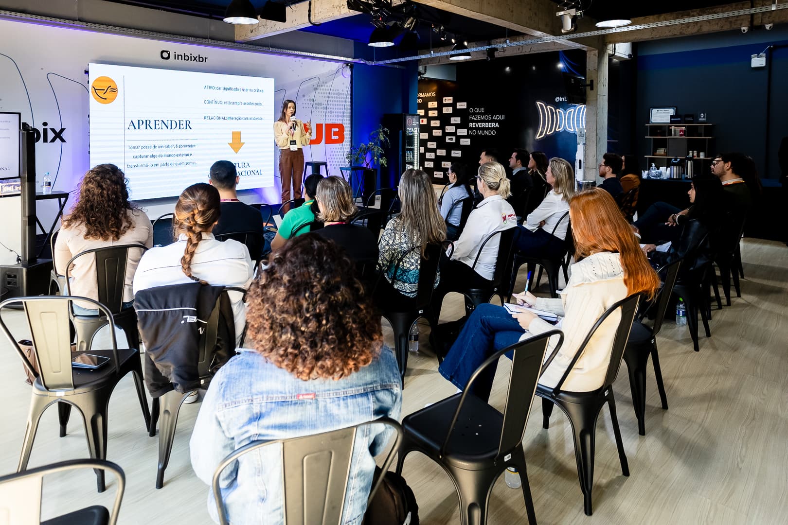 Palestrante apresentando para o público sentado no espaço de eventos da Inbix