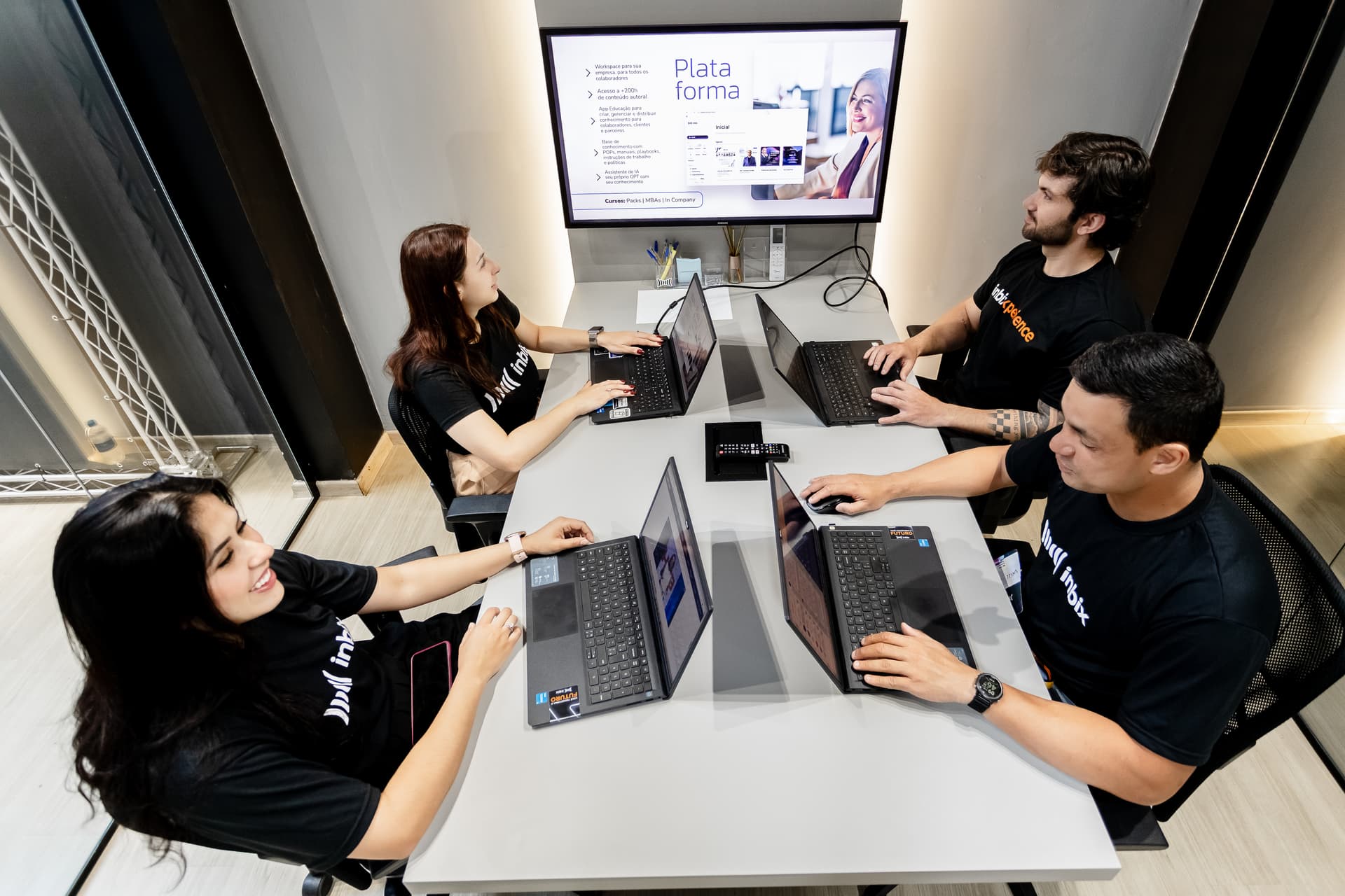 Equipe da Inbix em reunião diante do telão com a plataforma aberta