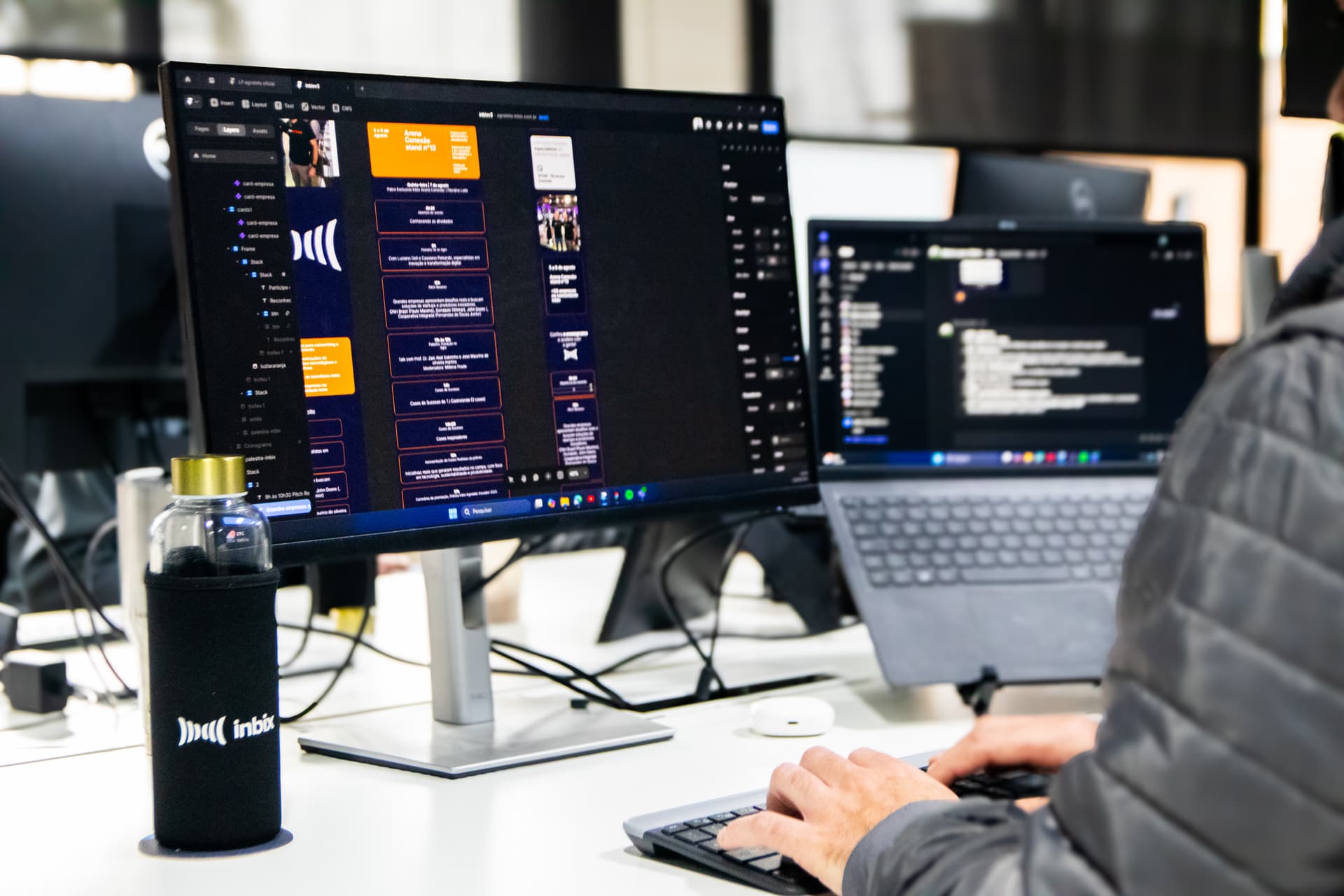 Profissional organizando conteúdo de treinamento em dois monitores